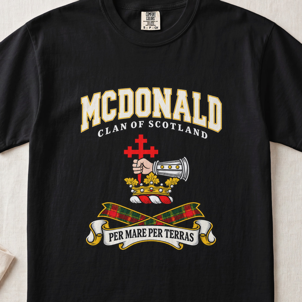 McDonald graphic T-shirt in Black, front flat lay showing varsity lettering and armoured forearm with hand holding red cross.