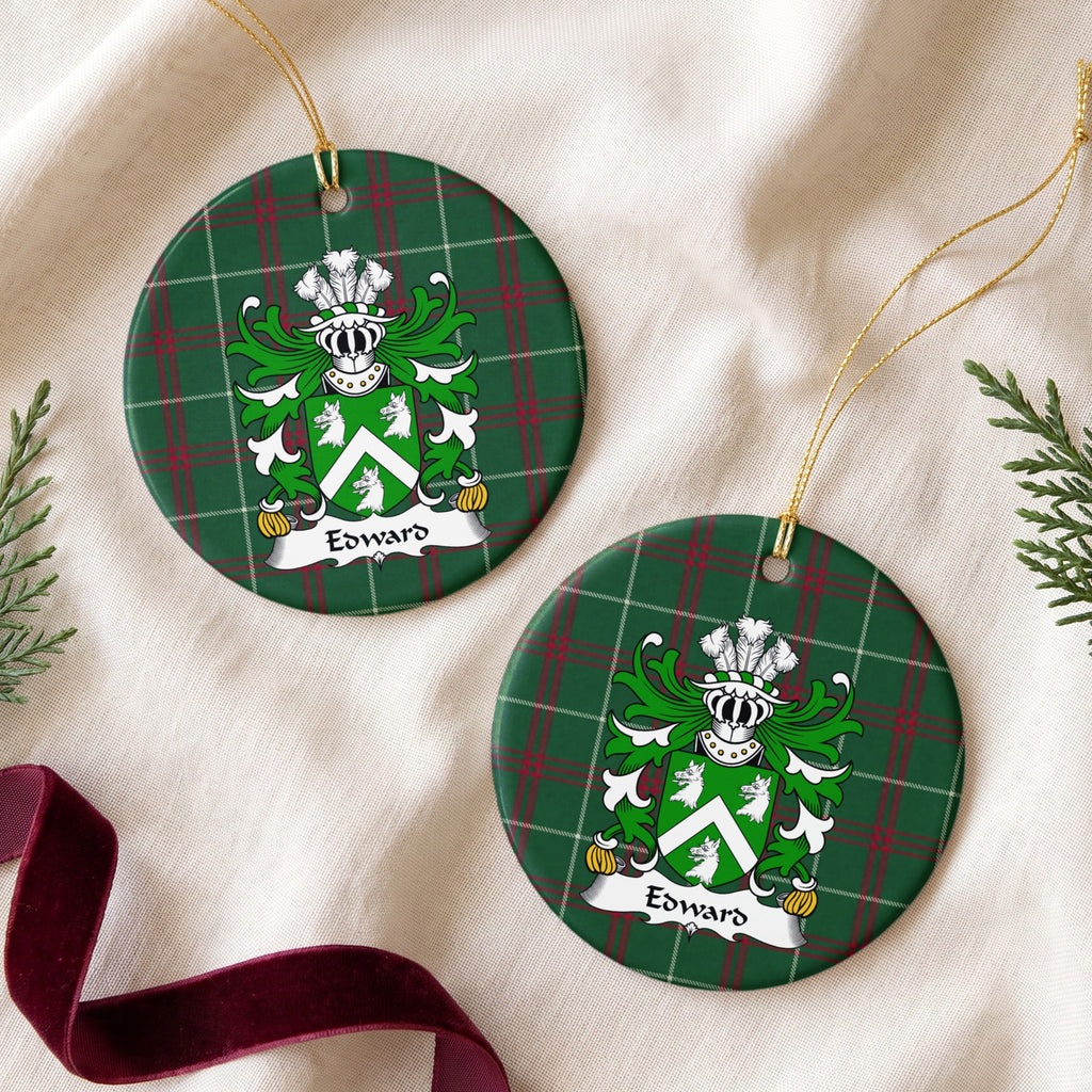 Two Edward Style 2 ornaments on cream fabric beside burgundy ribbon; a white chevron between three white wolf heads on a green shield on Welsh national tartan.