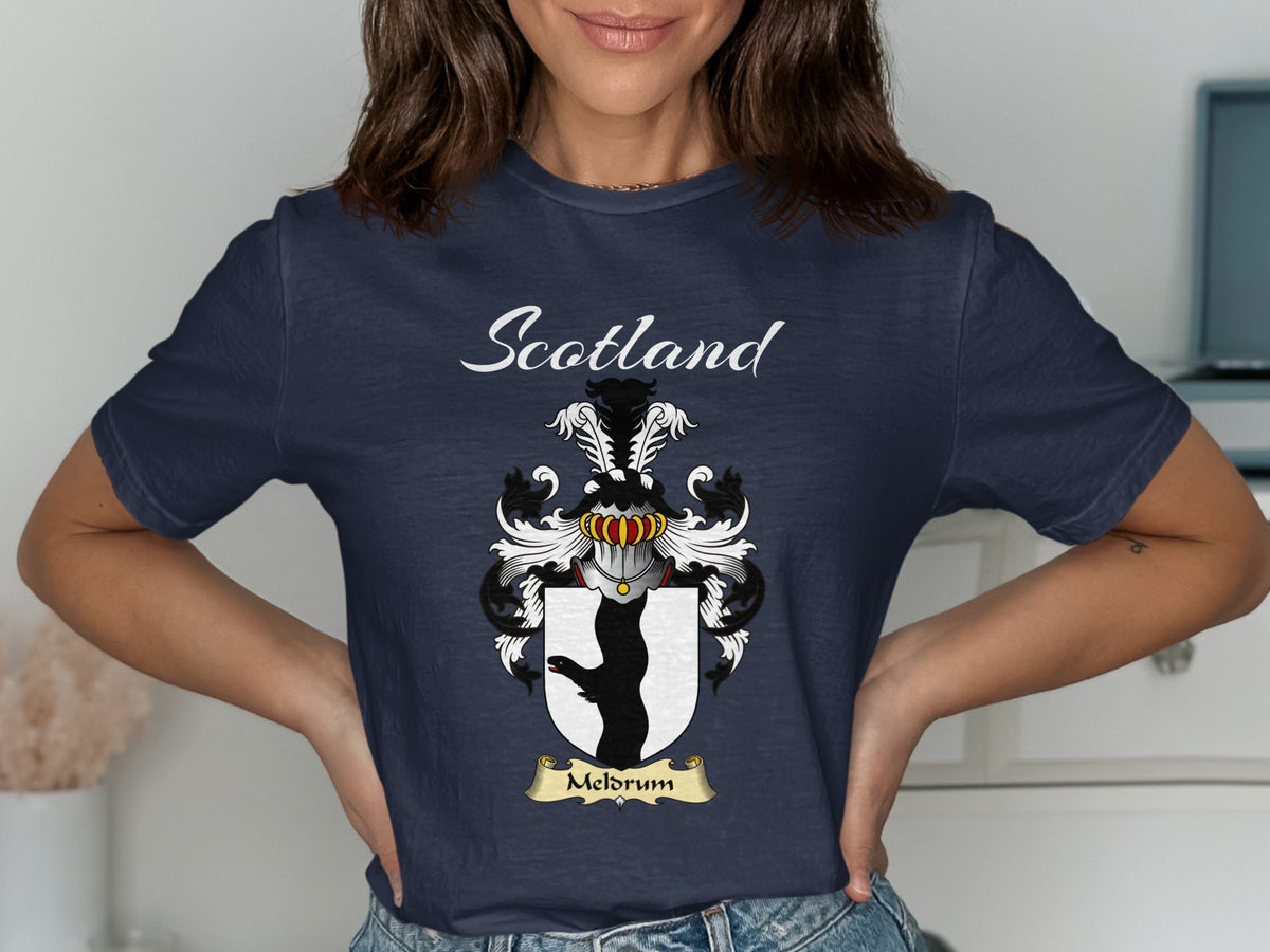 Model wearing a navy Meldrum T-shirt featuring a black animal-leg silhouette on a white shield