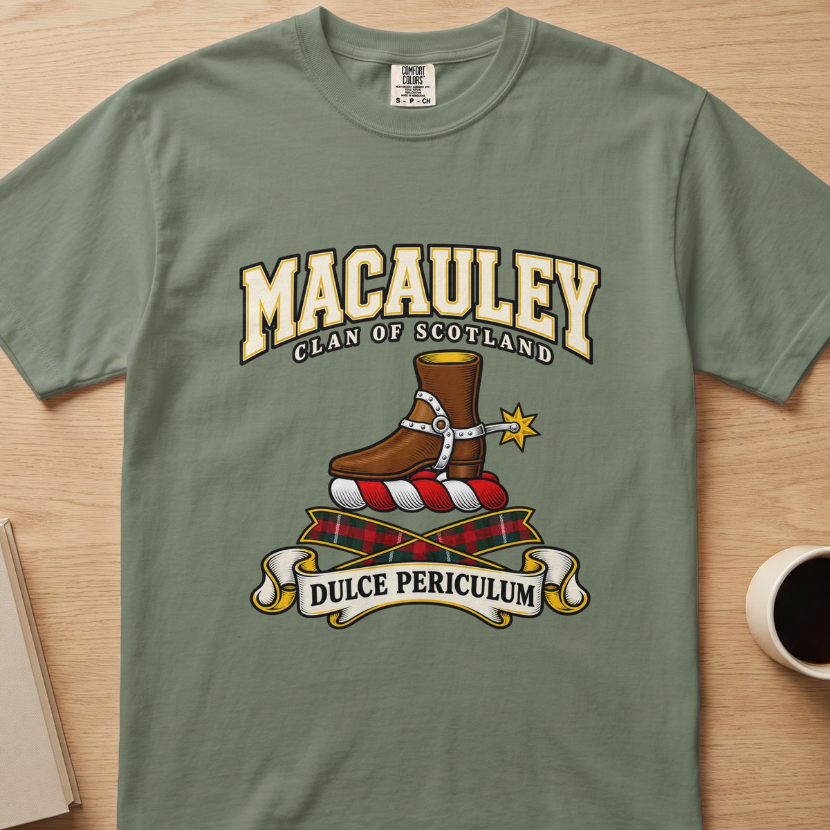 MacAuley brown boot and gold spur crest graphic on a sage green Comfort Colors T-shirt, front view