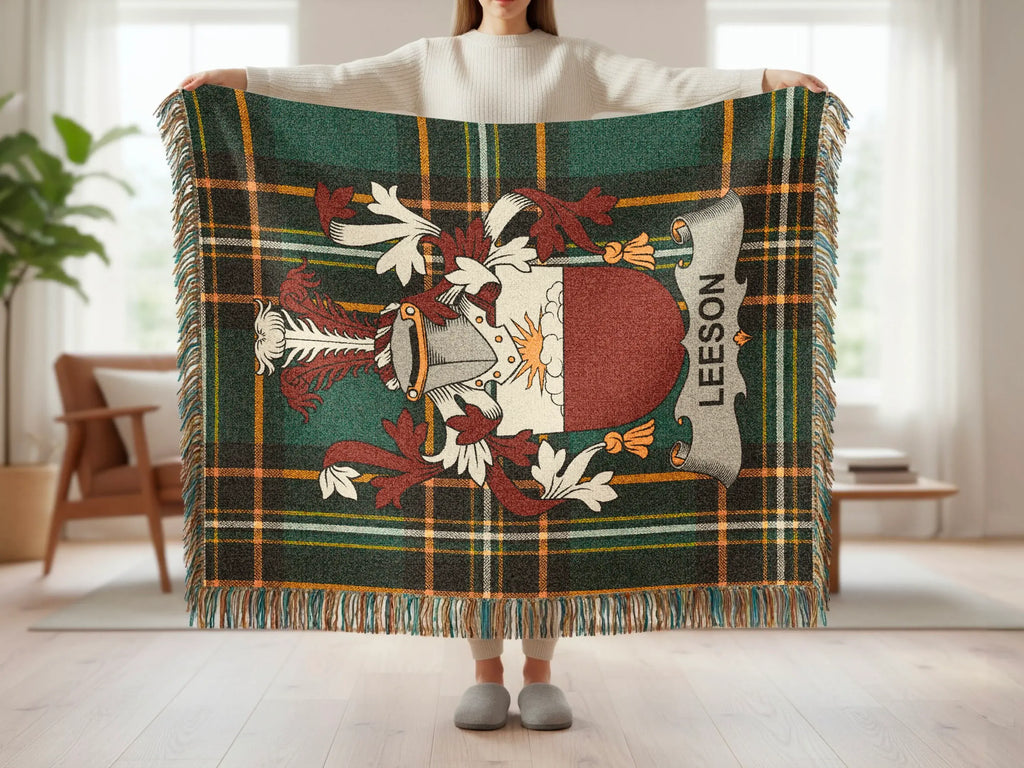 Leeson plaid throw blanket with crest design, held by person.