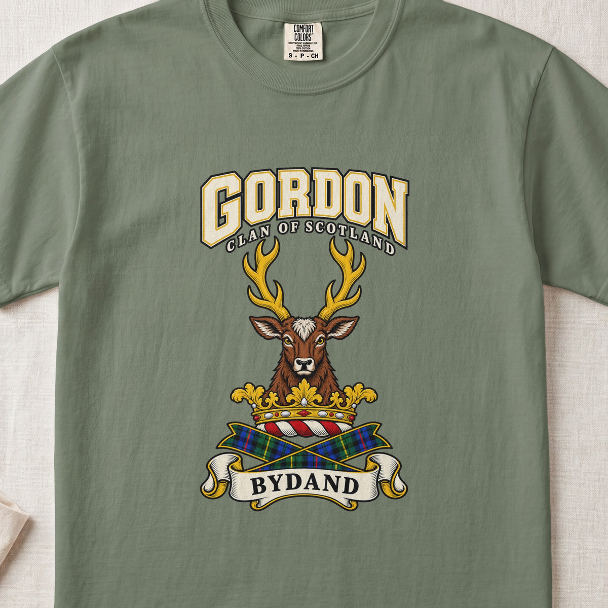 Gordon graphic T-shirt in Moss green, front flat lay showing varsity lettering and forward-facing brown stag head with gold antlers.