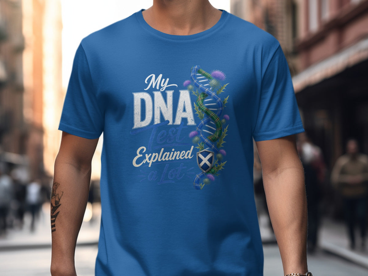 Blue t-shirt with text "My DNA Test Explained a Lot" and Scottish DNA graphic.