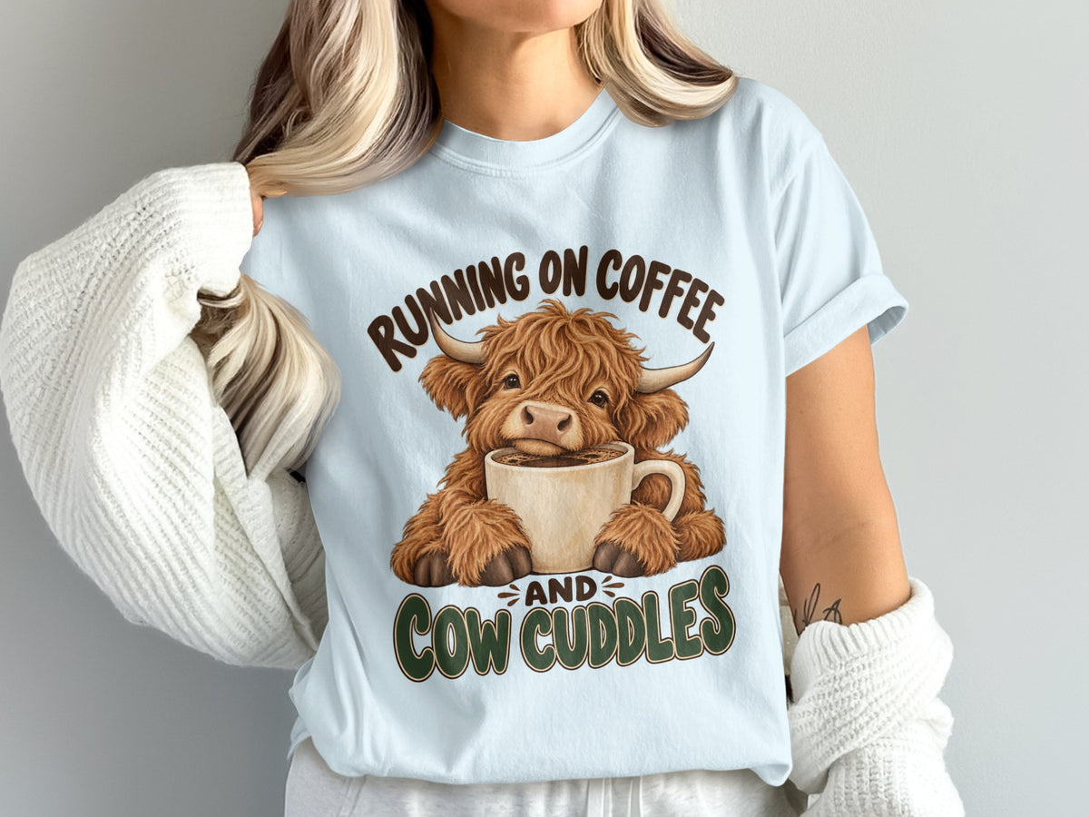 Model wearing the Running on Coffee & Cow Cuddles Highland cow Comfort Colors T-shirt in Chambray