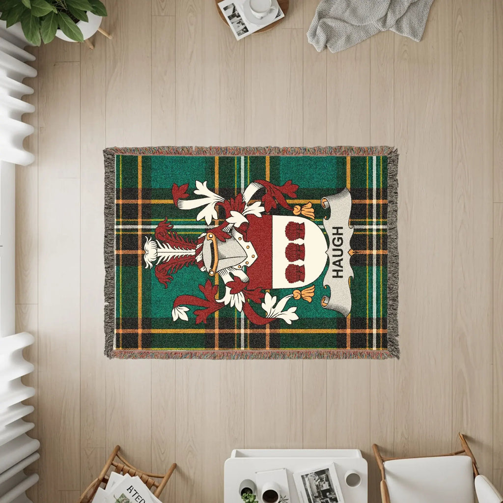 Woven blanket with Haugh family crest on tartan background.