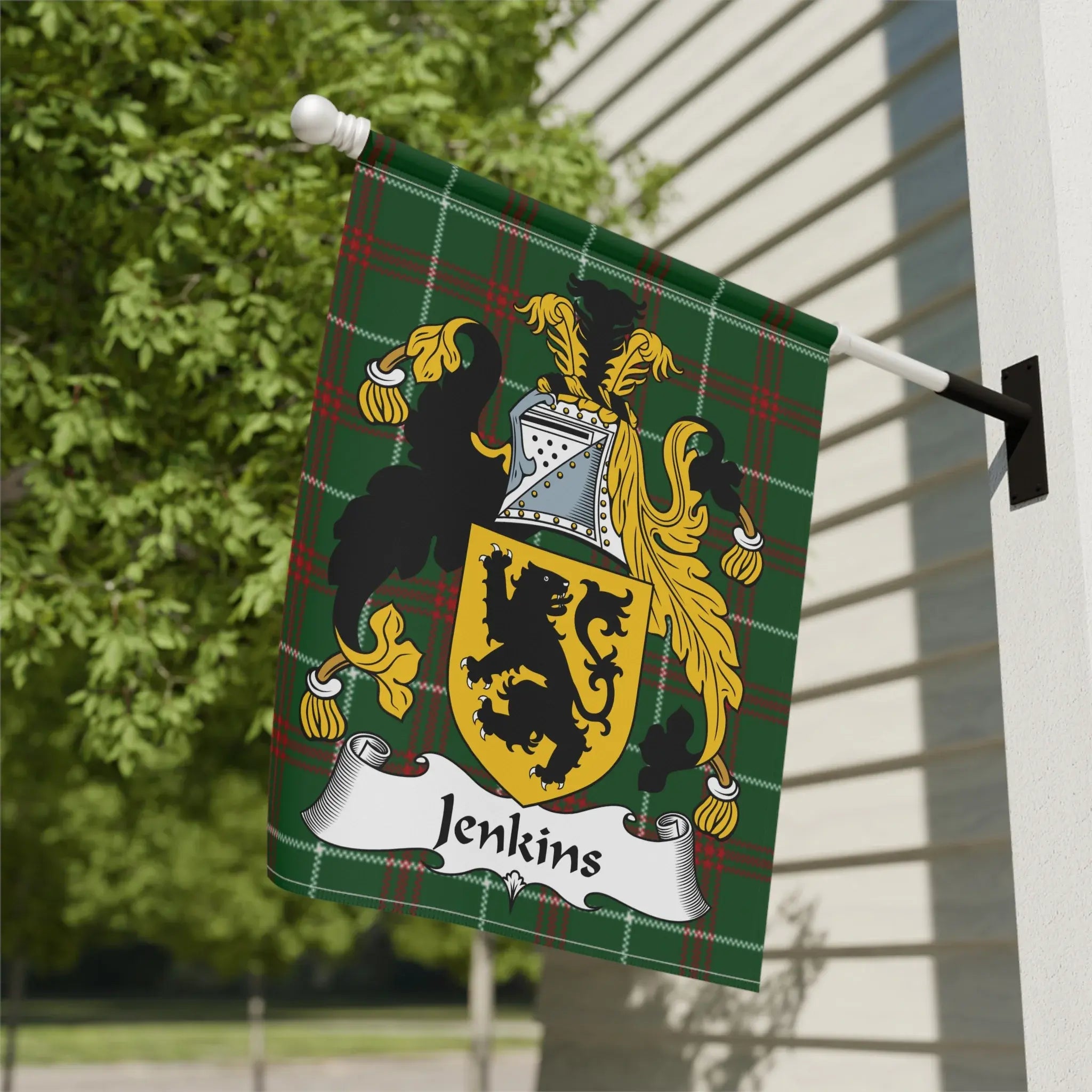Jenkins family crest on a green plaid flag against a building and foliage.