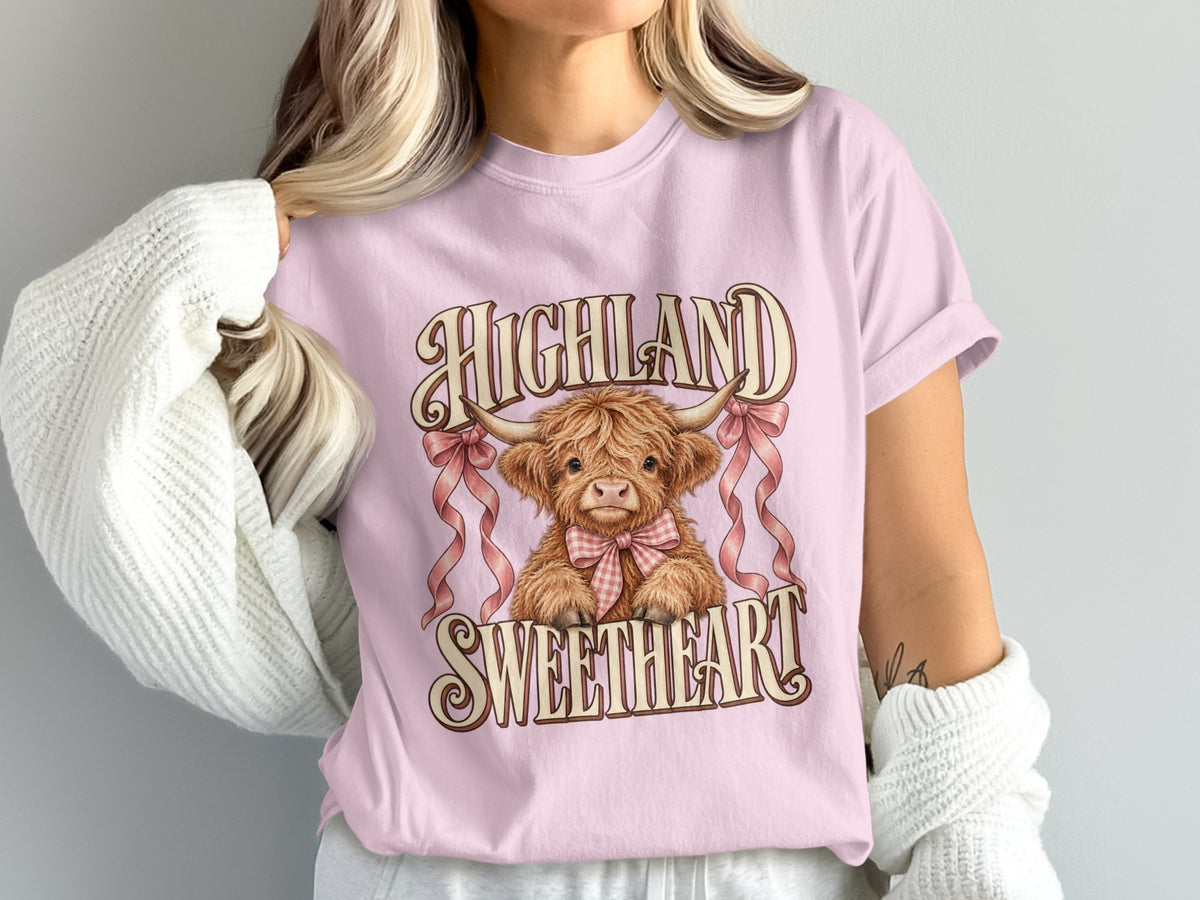 Model wearing the Highland Sweetheart Highland cow Comfort Colors T-shirt in Blossom