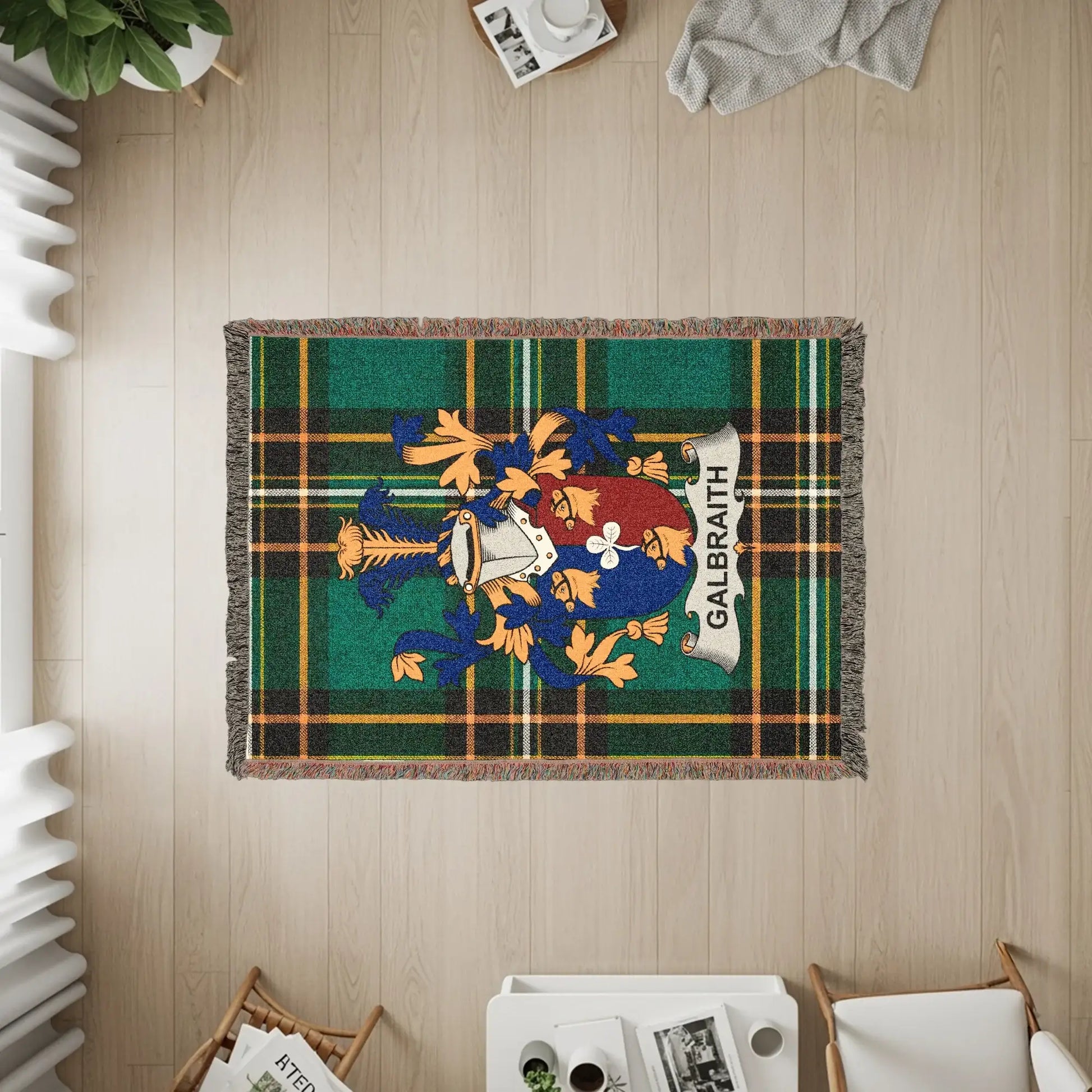 Galbraith tartan blanket with a coat of arms and fringe, displayed on a wooden floor.