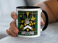Mug with a coat of arms and "Noble" text held by a hand.