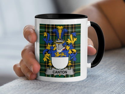 White mug with black rim and handle, displaying the Canton family crest on plaid.