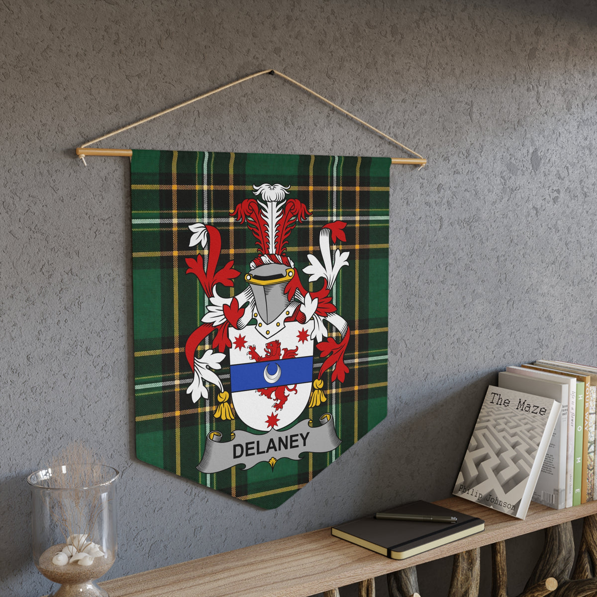 Delaney family crest on green tartan pennant hanging on wall.