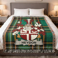 Tartan throw blanket with Heydon family crest on a bed.