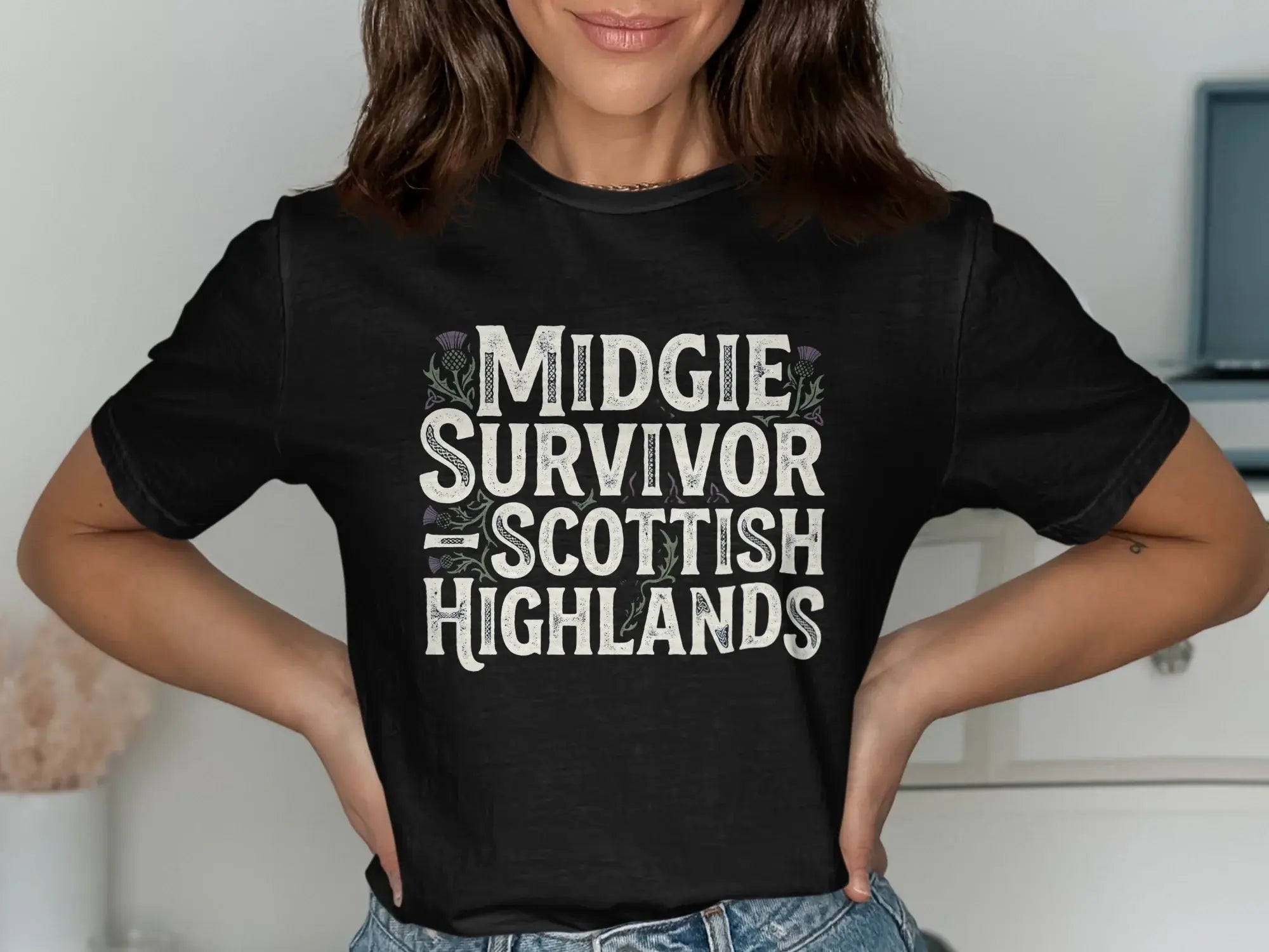 Black t-shirt with "Midgie Survivor Scottish Highlands" text and thistle design.