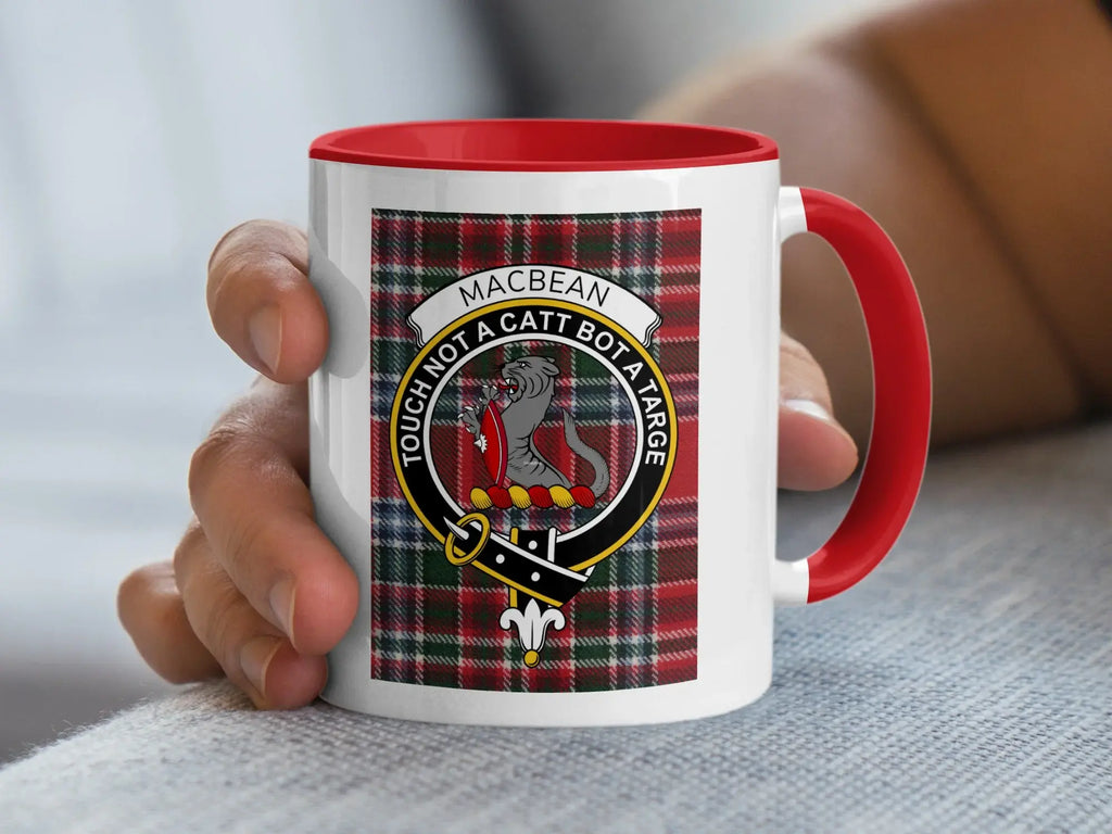 Macbean clan crest on tartan pattern mug with red handle.