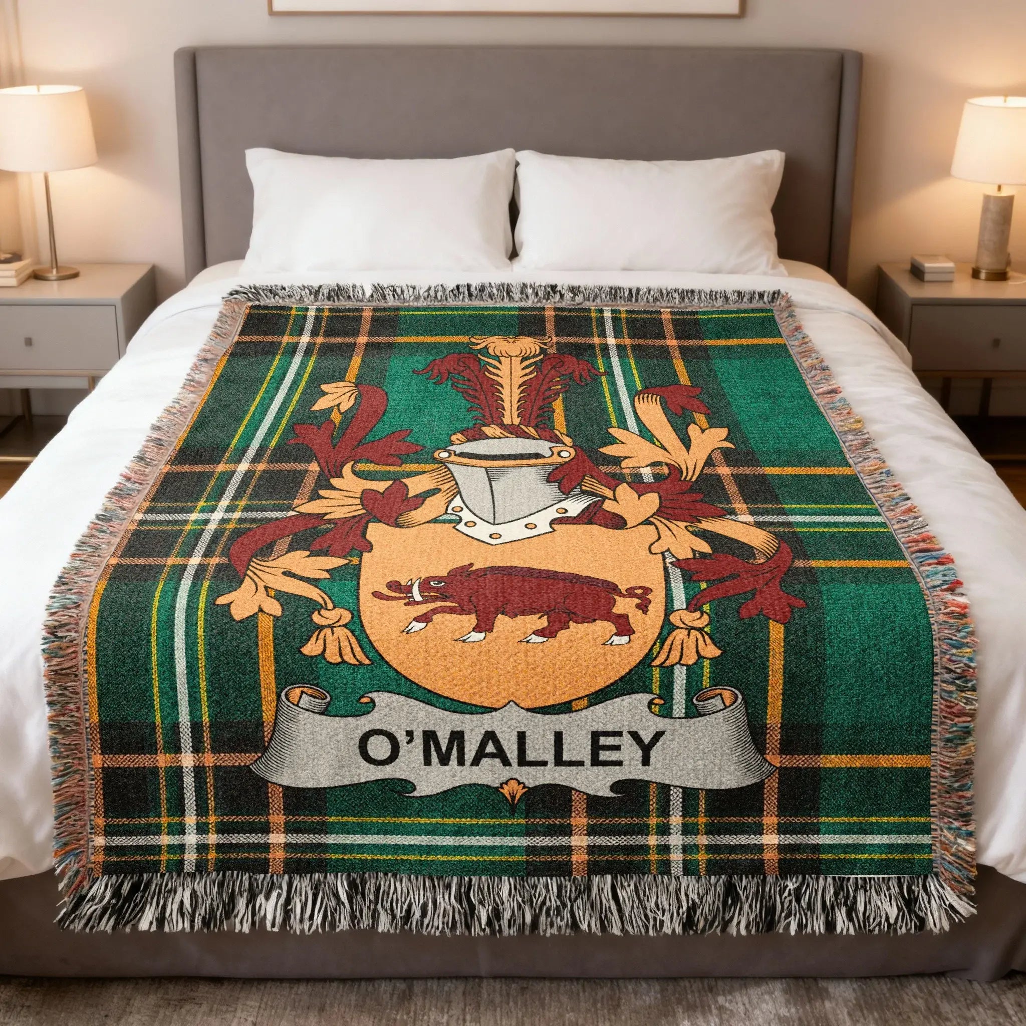 O'Malley tartan blanket with coat of arms draped on a bed.