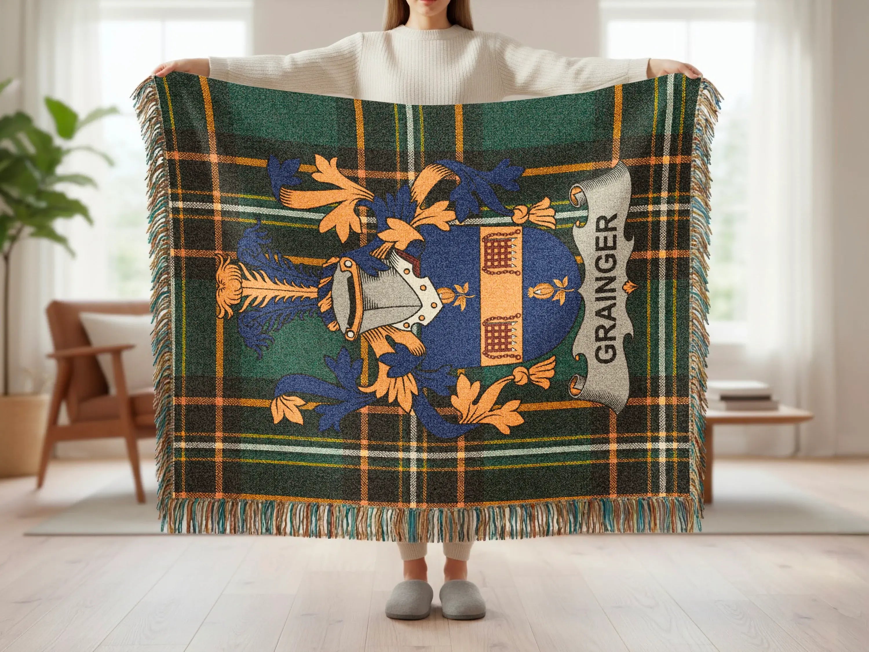 Grainger tartan crest blanket with fringe, held by person.