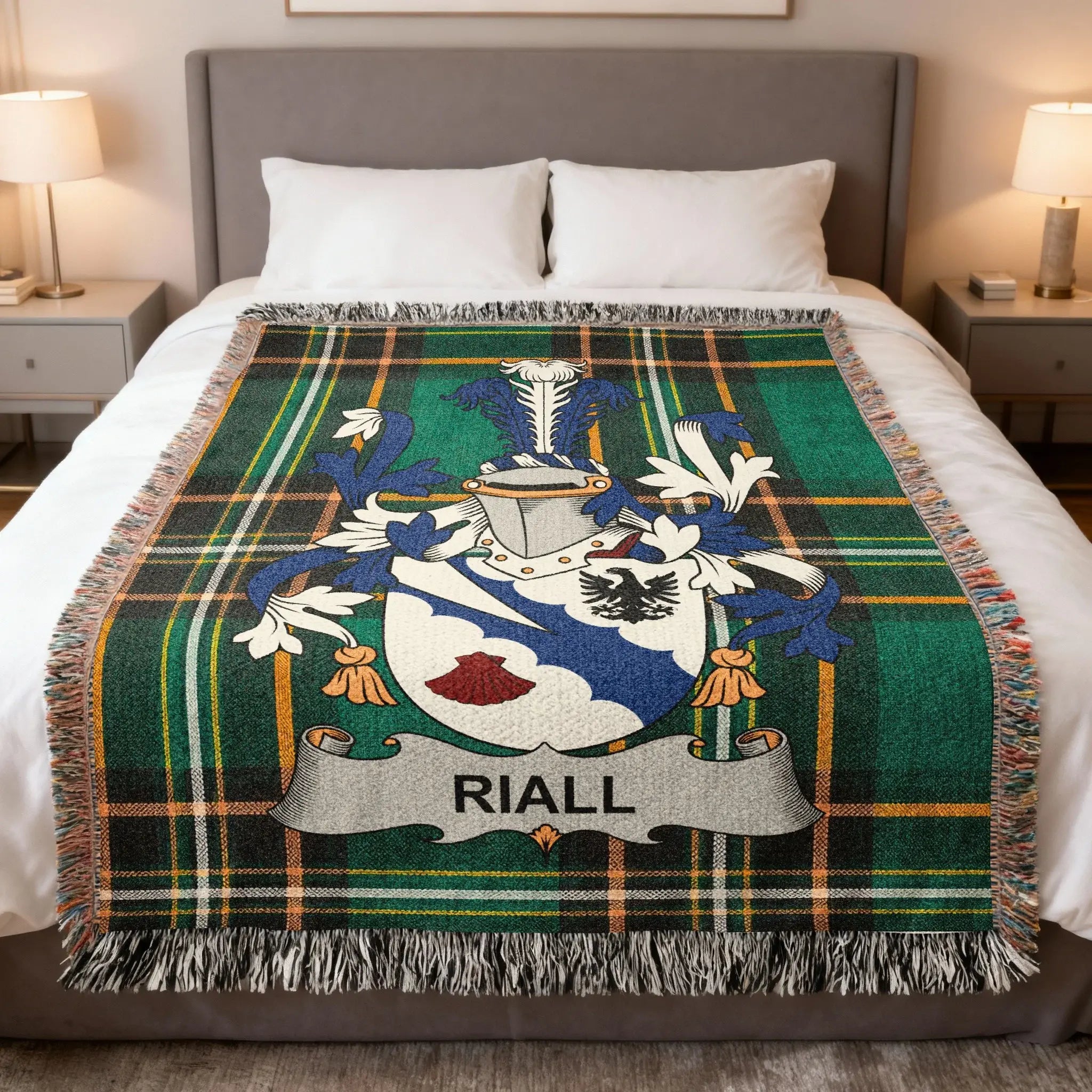 Riall family crest on green tartan woven throw blanket on a bed.