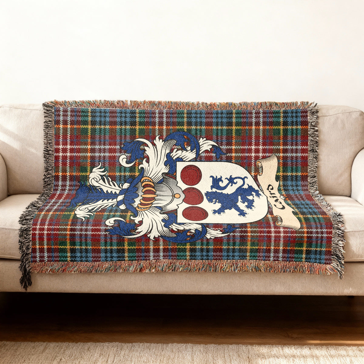 Caird Scottish woven blanket with family shield and Caledonia tartan background