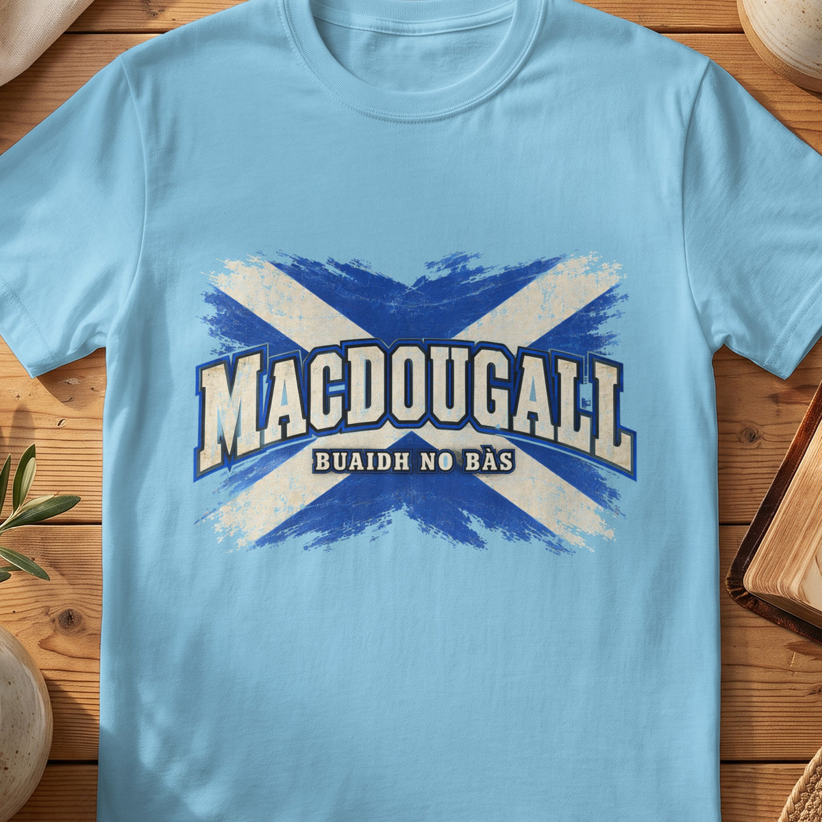 MacDougall Scottish Saltire T-shirt in Sky, with distressed blue and cream flag and “Buaidh No Bàs” lettering.