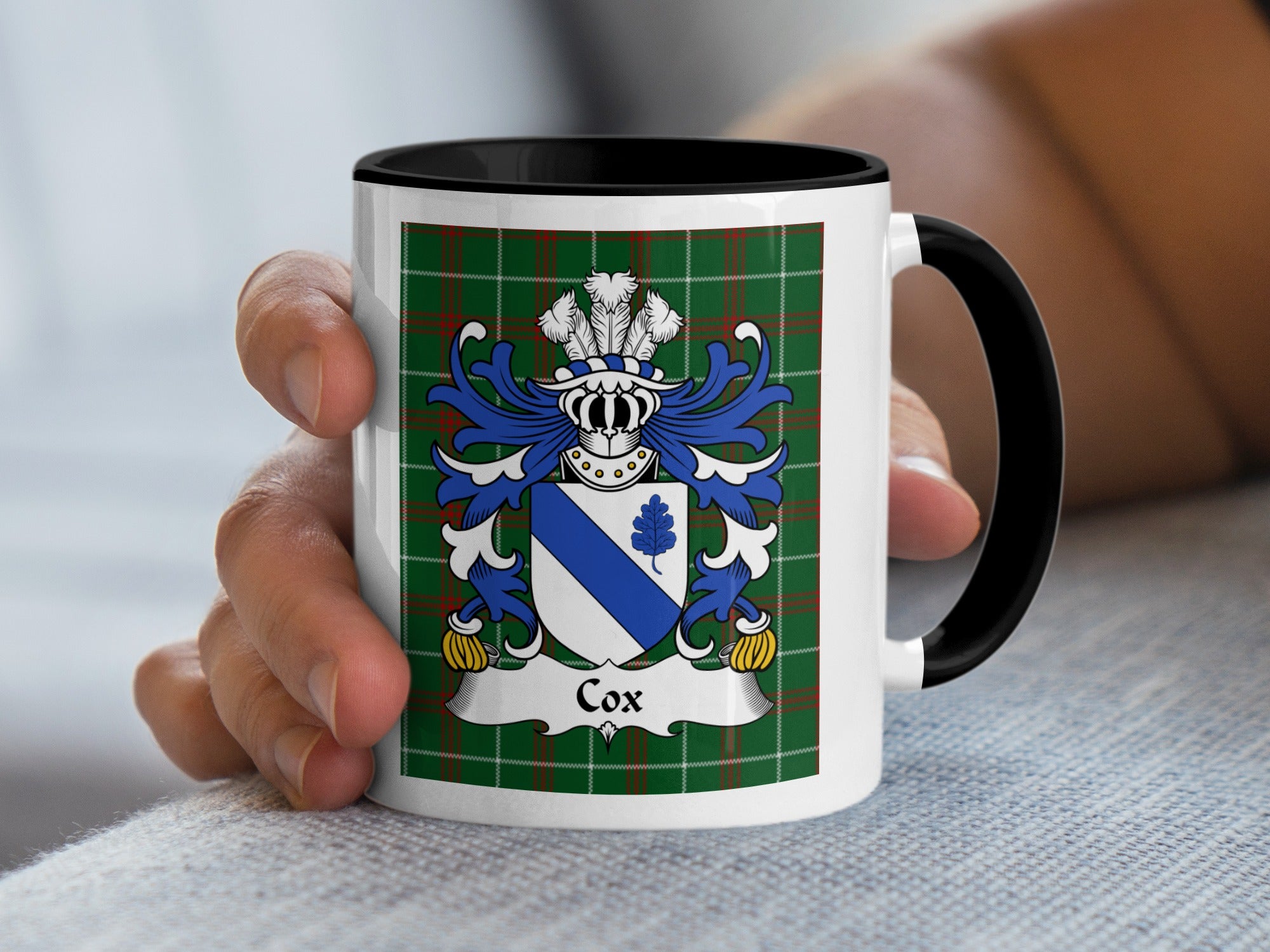 White mug with black handle features the Cox family crest on a green tartan background.