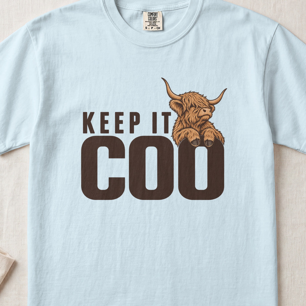 Keep It Coo Highland cow design on a Chambray Comfort Colors 1717 T-shirt, flat lay
