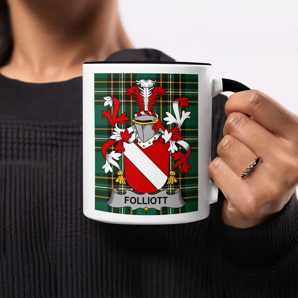 White mug with black handle displaying a family crest on plaid background.
