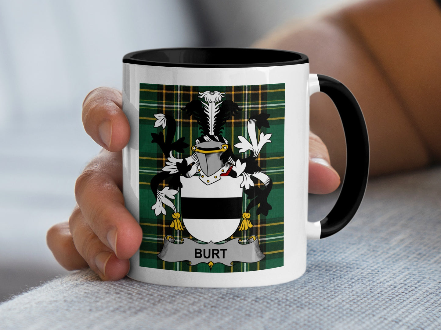 White mug with black rim and handle, featuring a family crest with "BURT" on a tartan background.