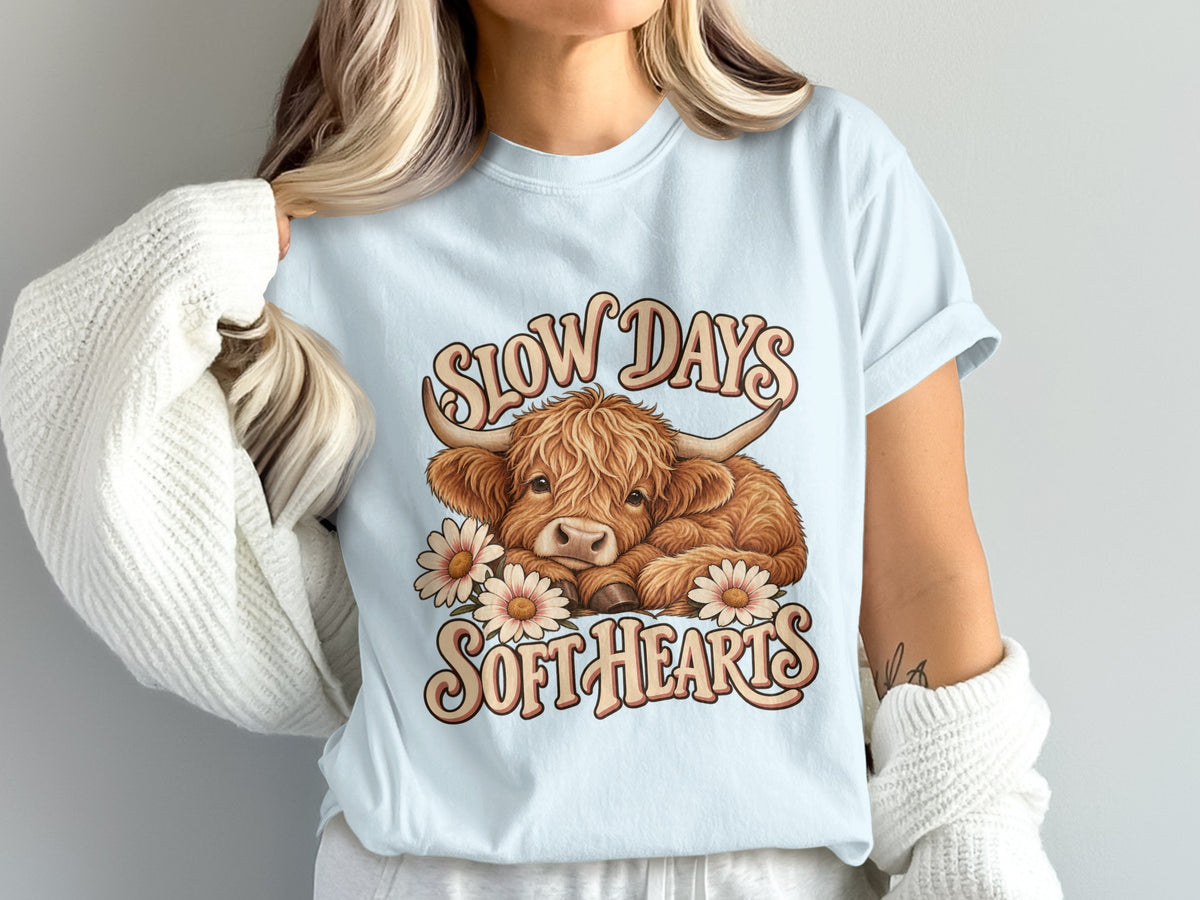 Model wearing the Slow Days, Soft Hearts Highland cow Comfort Colors T-shirt in Chambray