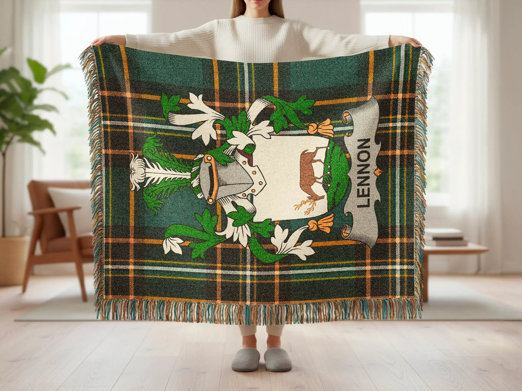 Tartan blanket with crest featuring "LENNON" text held by person.