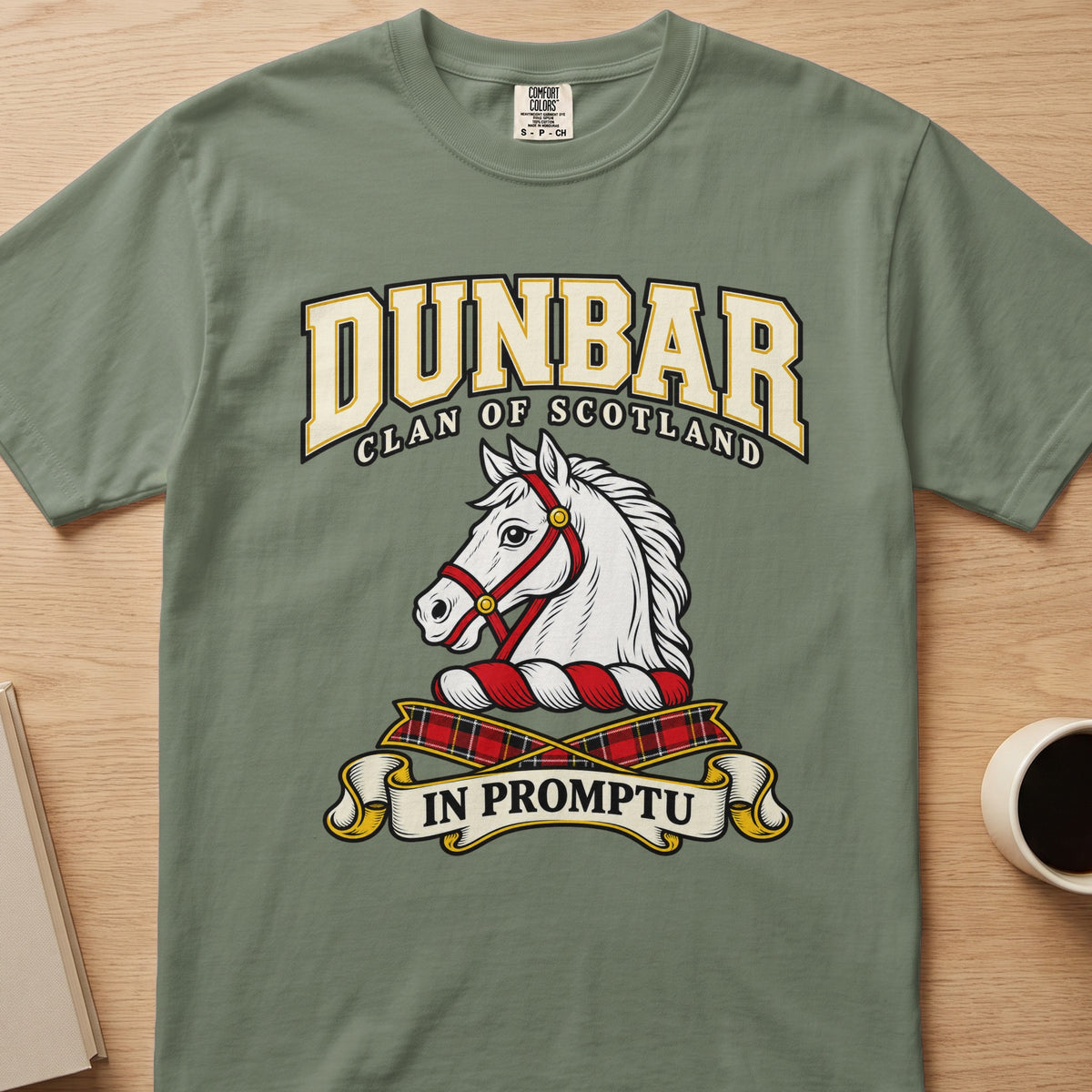 Dunbar clan crest with white horse head on a sage green Comfort Colors T-shirt, front view
