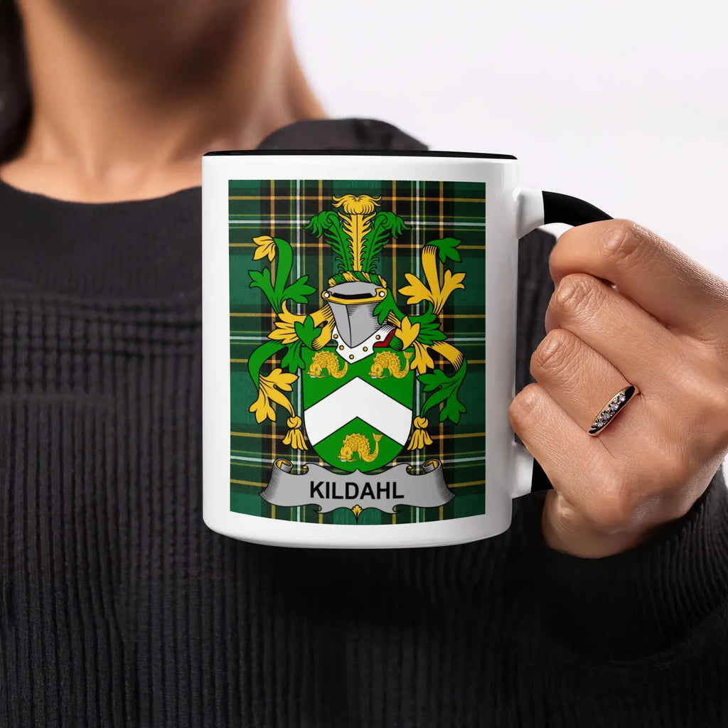 Mug with a green, yellow, and black plaid pattern and a coat of arms with the name KILDAHL.