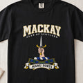 MacKay graphic T-shirt in Black, front flat lay showing varsity lettering and hand and forearm holding an upright silver dagger with gold hilt.