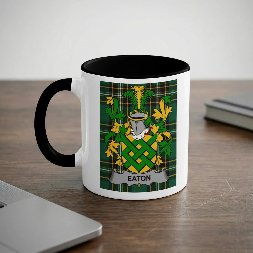 White mug with black handle featuring the Eaton family crest on a tartan background.