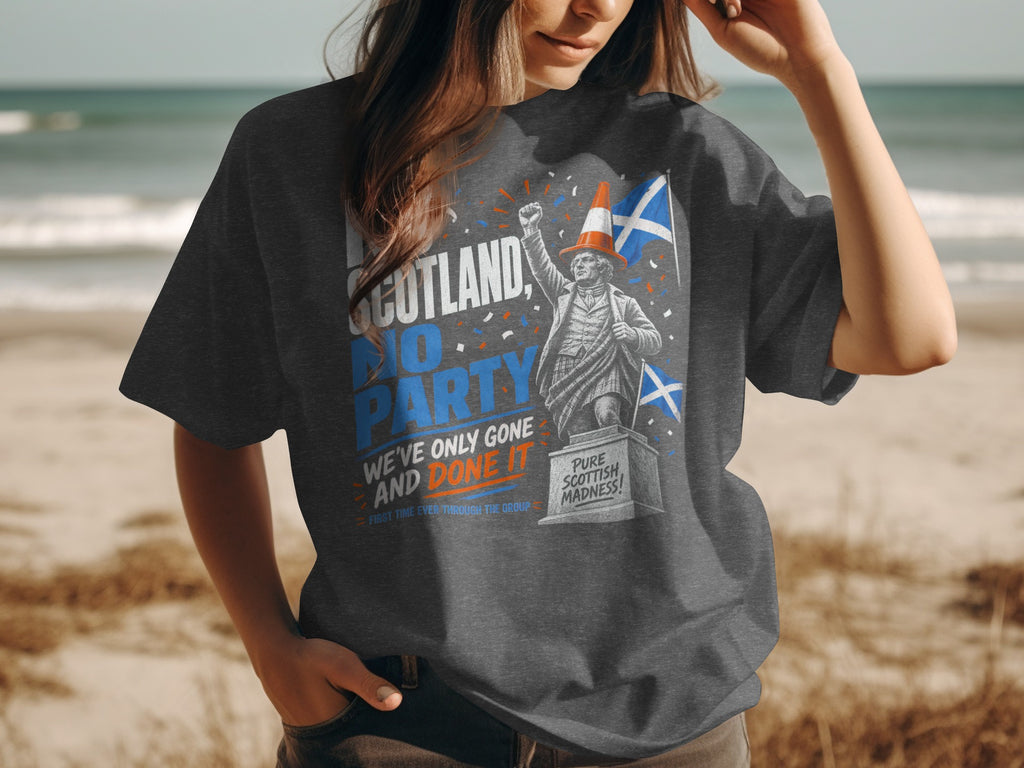 T-shirt with Scotland party slogan and statue, beach background.