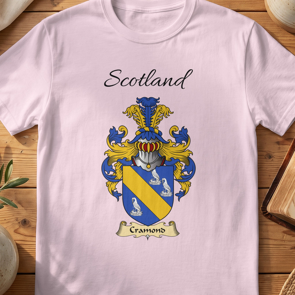 Light Pink Cramond Scottish family shield T-shirt featuring a gold diagonal band between pale motifs on blue
