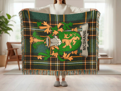 Green and orange tartan blanket with a family crest and "MCSHANE" text.