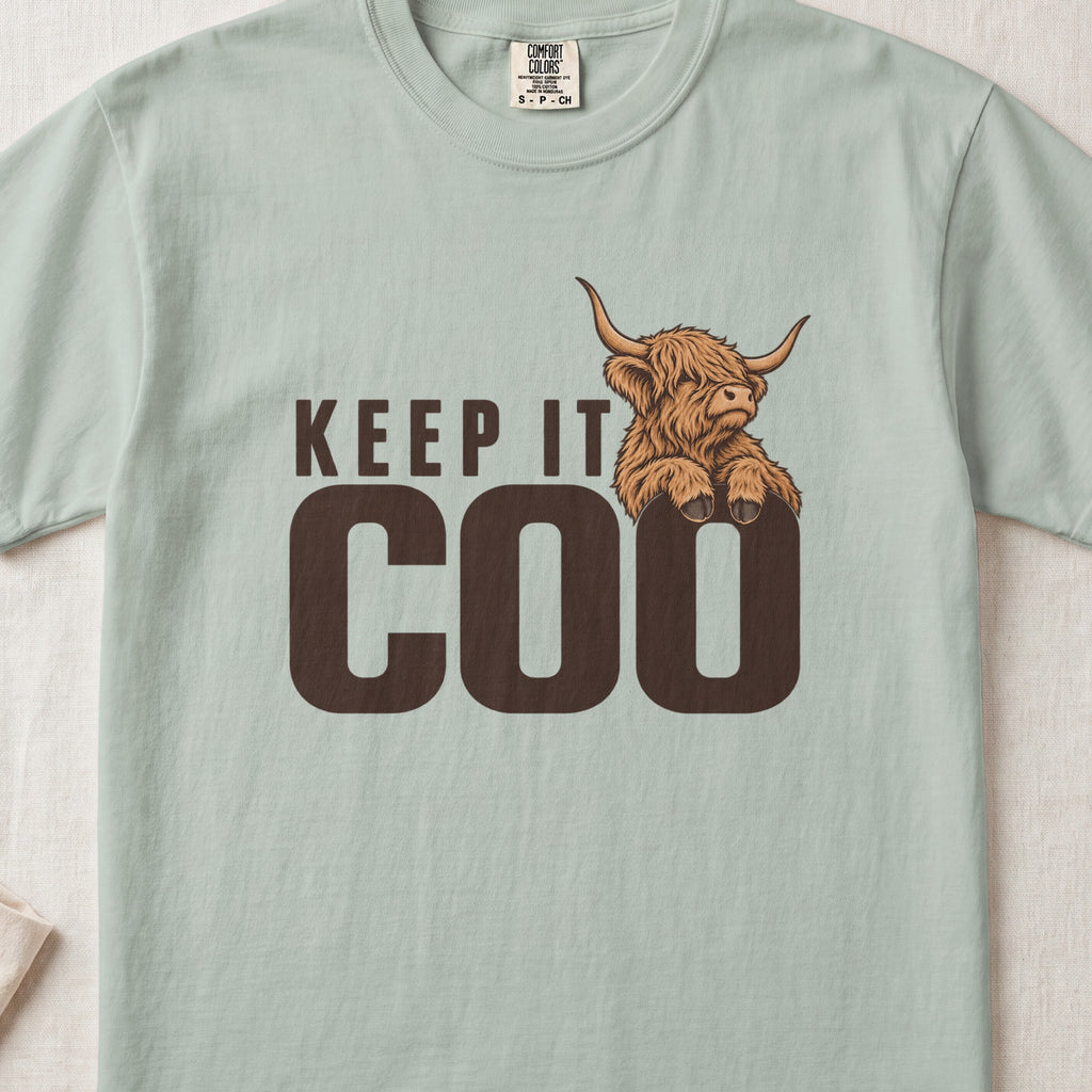 Keep It Coo Highland cow design on a Bay Comfort Colors 1717 T-shirt, flat lay