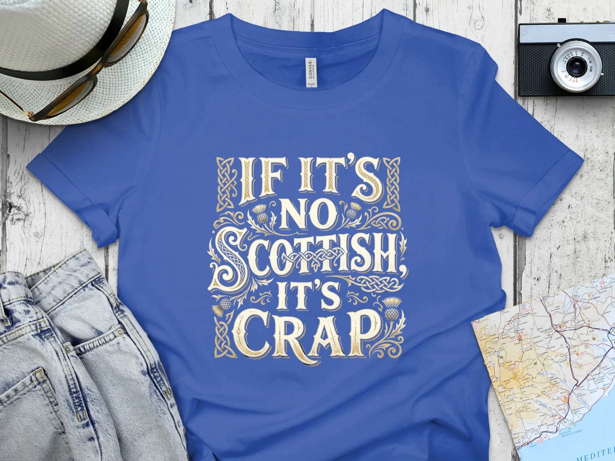 Blue t-shirt with gold text "If it's no Scottish, it's crap" and Celtic knotwork.