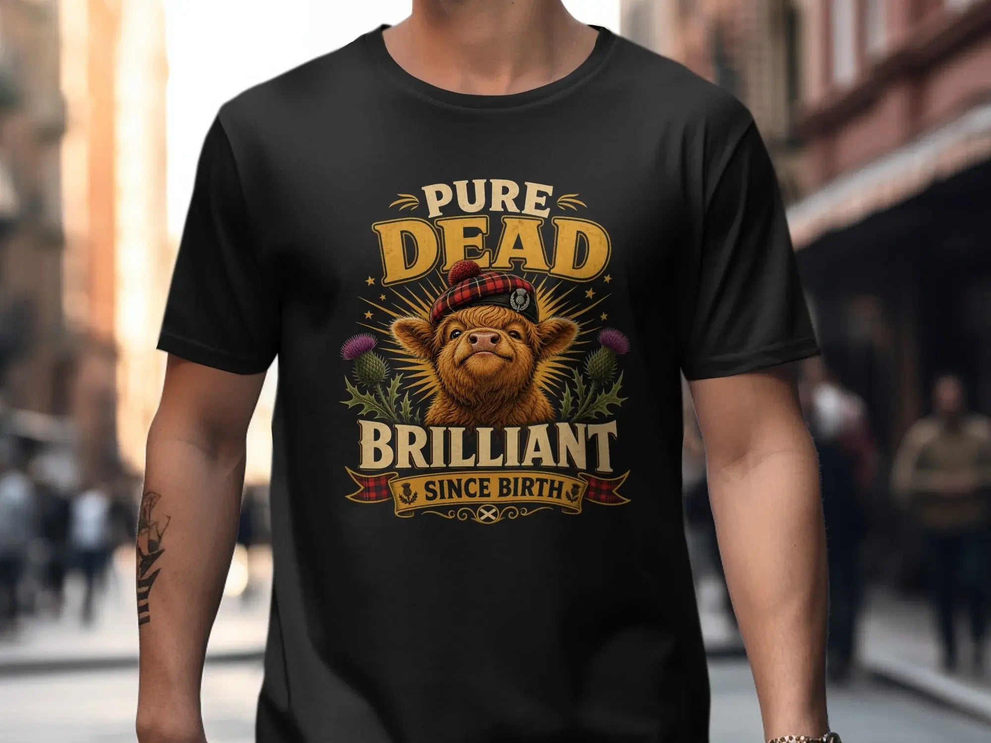 T-shirt with a highland cow wearing a Scottish cap and thistles.