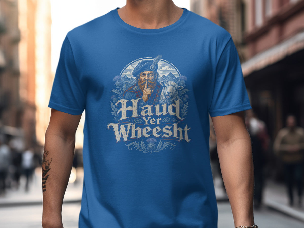 Blue t-shirt with graphic of Scottish man, sheep, mountains, and thistles, text reads "Haud Yer Wheesht".