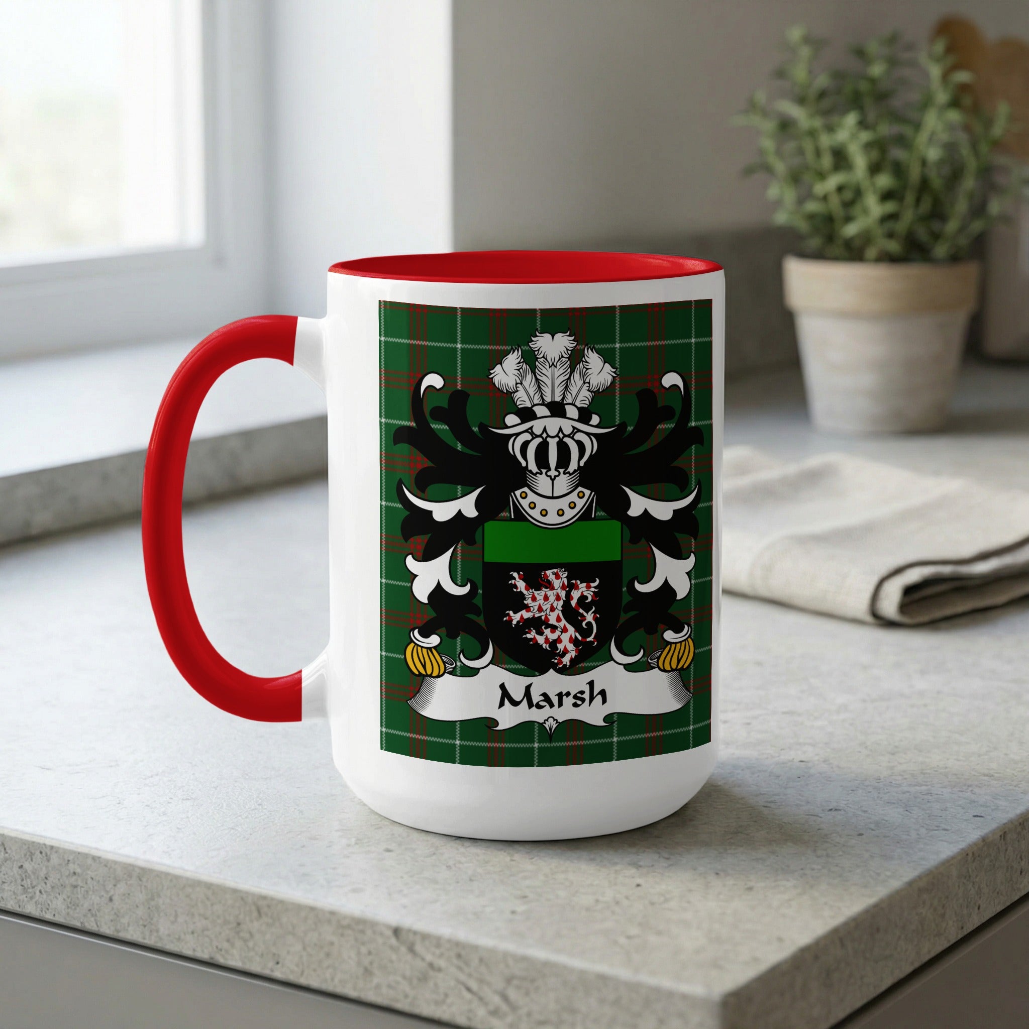 White mug with red handle, featuring a green plaid design and the Marsh coat of arms.