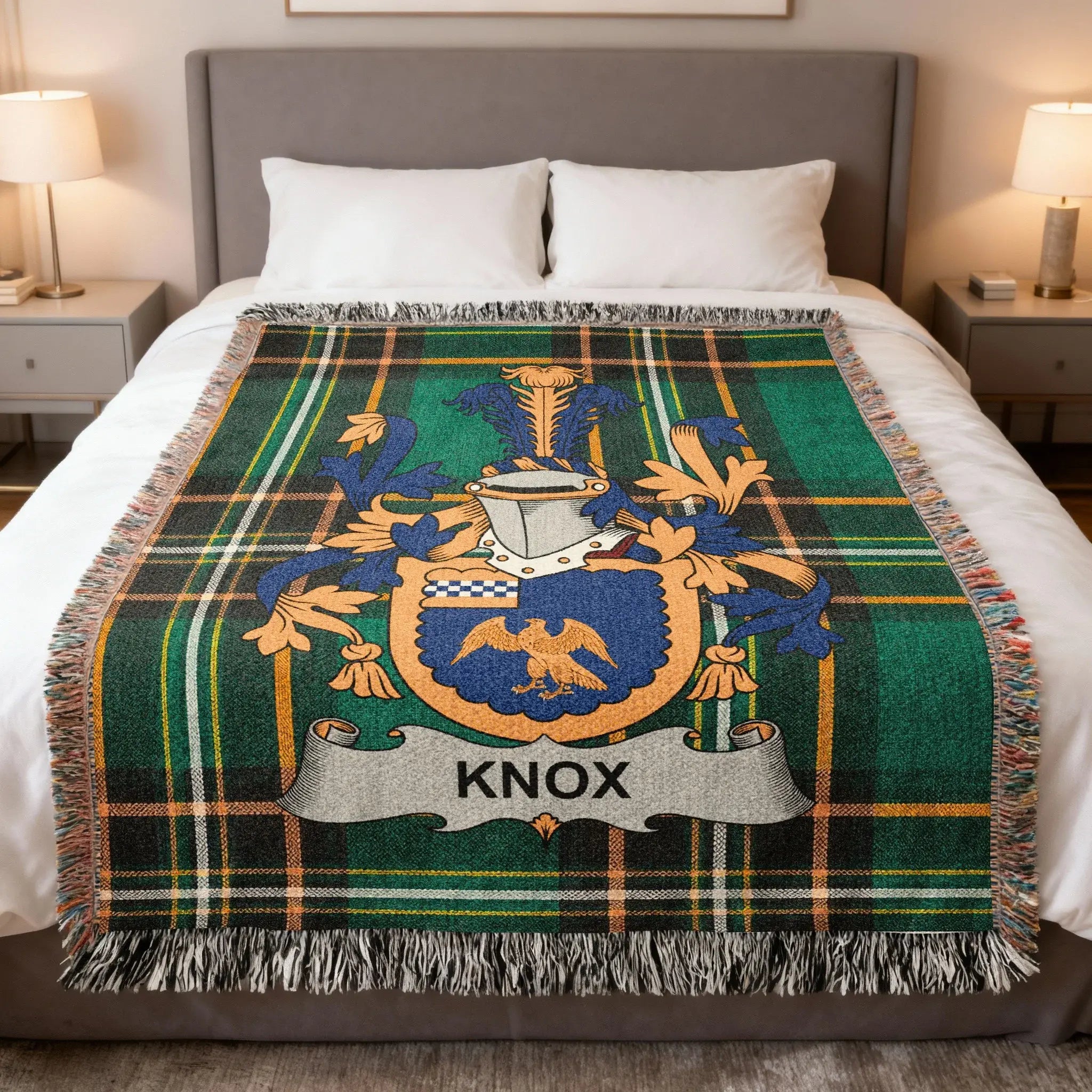 Green tartan blanket with Knox family crest on a bed.
