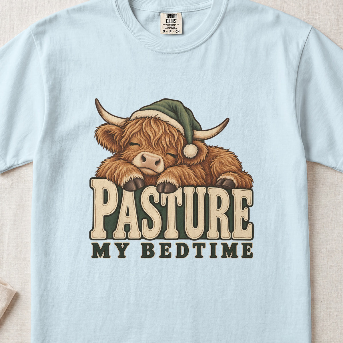 Pasture My Bedtime Highland cow design on a Chambray Comfort Colors 1717 T-shirt, flat lay