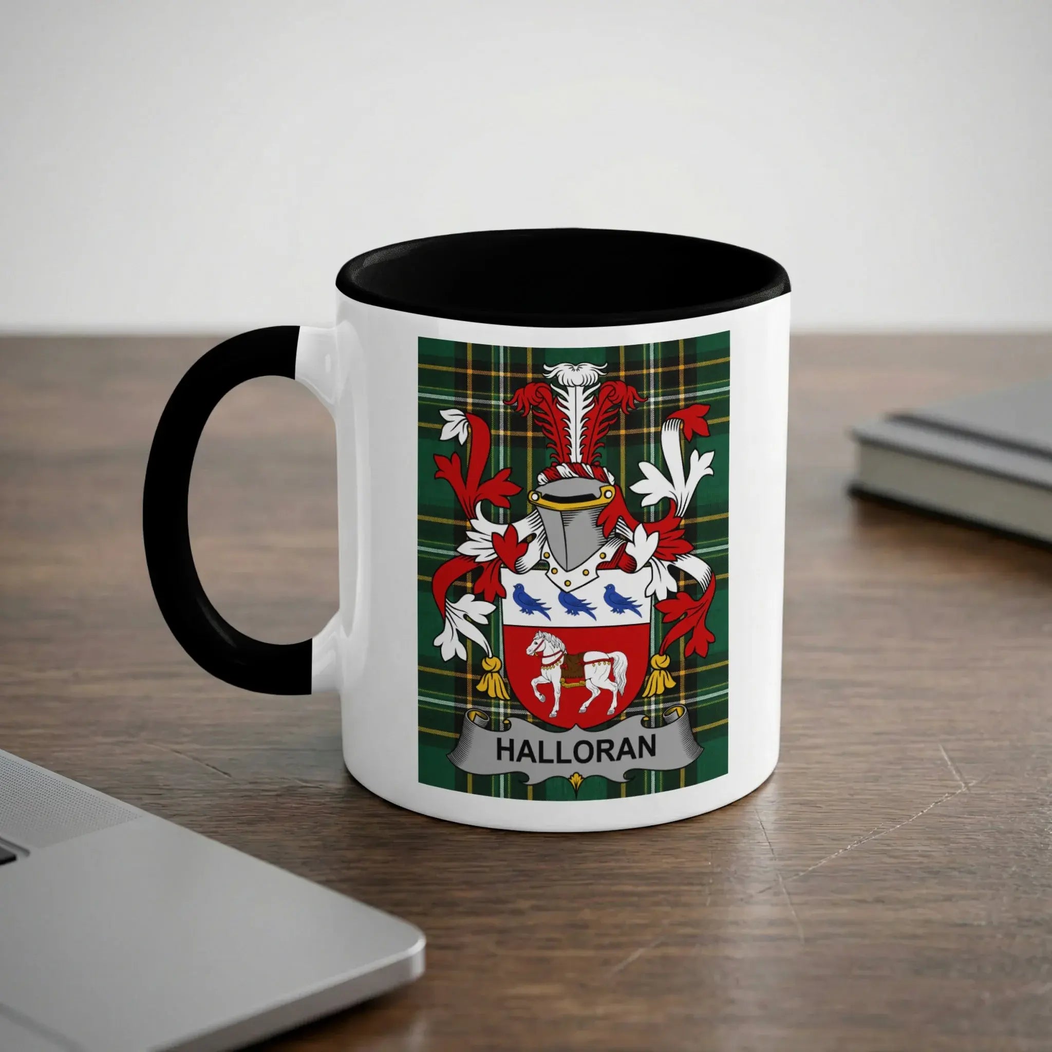 White mug with black rim and handle displaying a Halloran family crest on a green plaid background.
