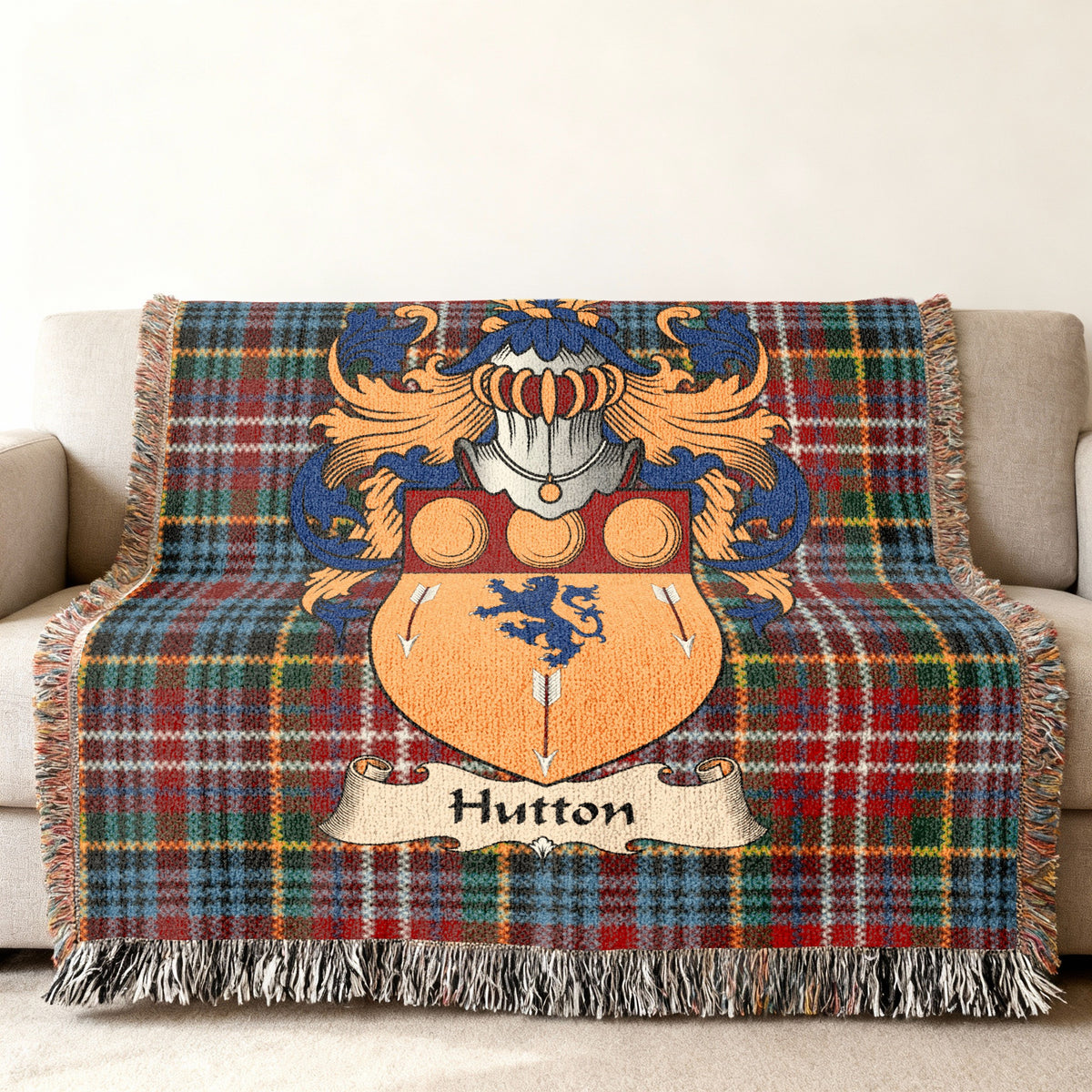 Hutton family crest emblem on a Caledonia tartan woven blanket