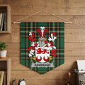 Kavanagh family crest on a green tartan banner against a wood panel wall.