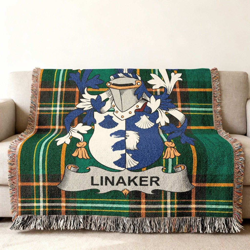 Green tartan blanket with the Linaker family crest draped on a sofa.