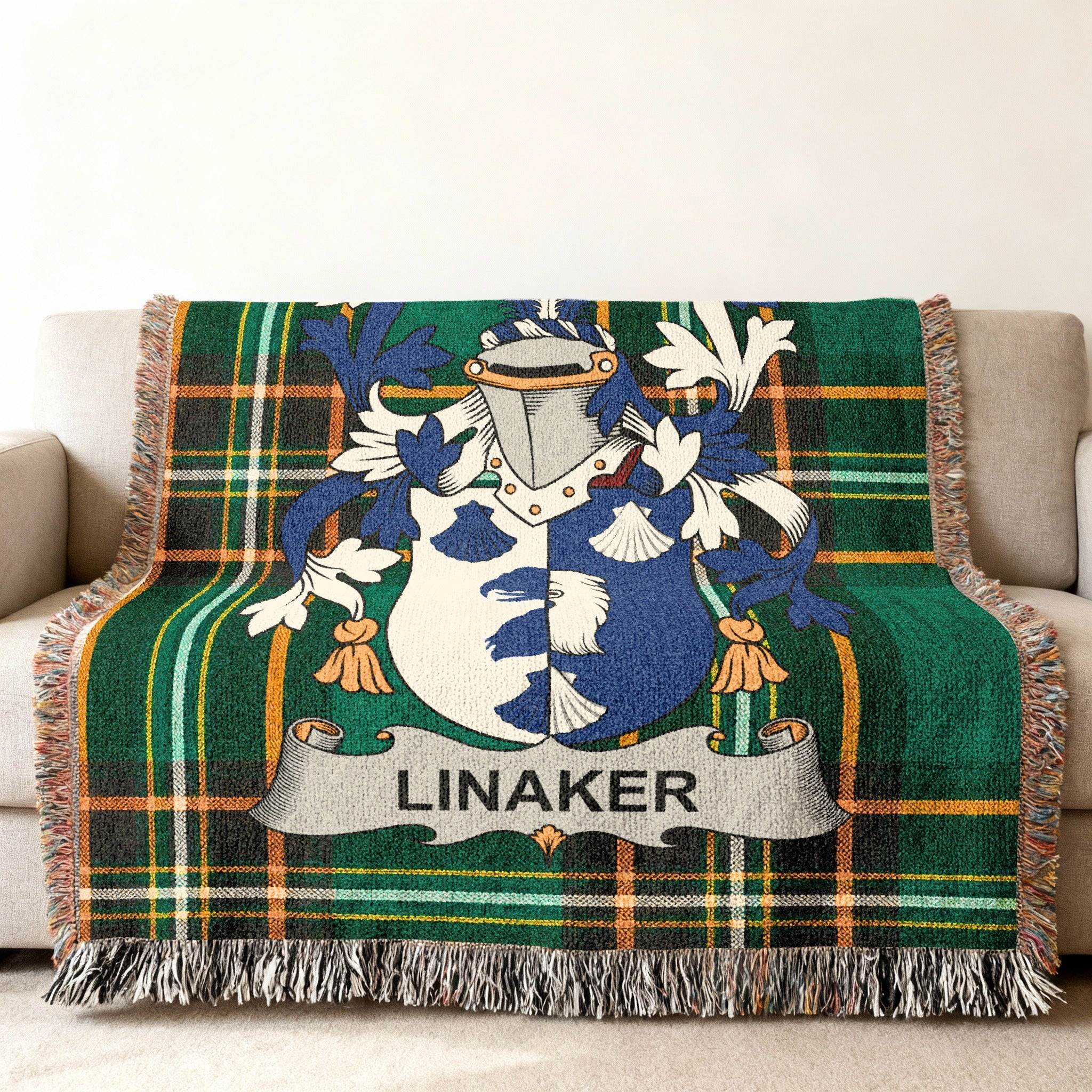Green tartan blanket with the Linaker family crest draped on a sofa.