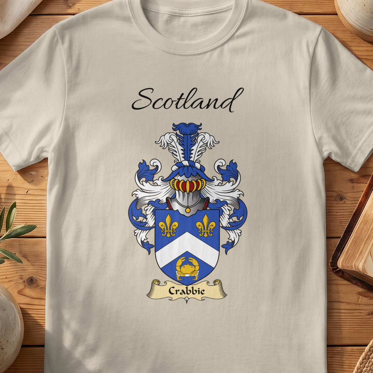 Sand Crabbie Scottish family shield T-shirt featuring a white chevron and gold motifs on blue