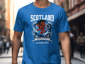 Blue t-shirt with a Scottish lion emblem and "SCOTLAND TARTAN ARMY CAN MEX USA 2026".